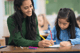 Educator assisting a student at her desk